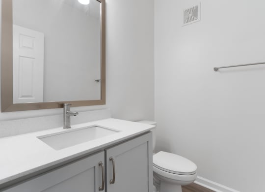 a bathroom with a sink and a toilet and a mirror at The Charleston, Columbus