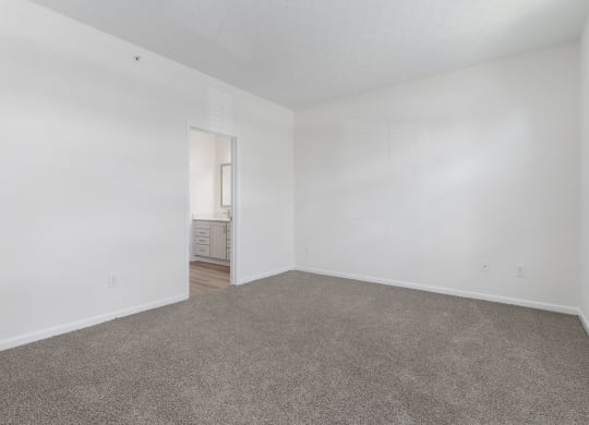 an empty living room with carpet and white walls at The Charleston, Columbus, OH, 43221