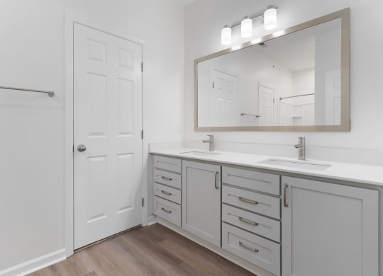 a bathroom with white cabinets and a sink and a mirror at The Charleston, Columbus, OH, 43221