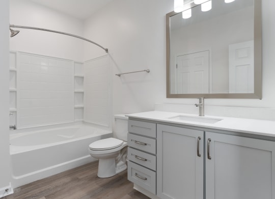 a white bathroom with a tub and a sink and a toilet at The Charleston, Columbus, 43221