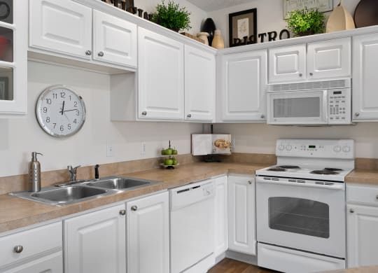 a kitchen with white cabinets and appliances and a clock at The Charleston, Columbus, 43221