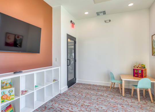 a play room with a table and chairs and a television