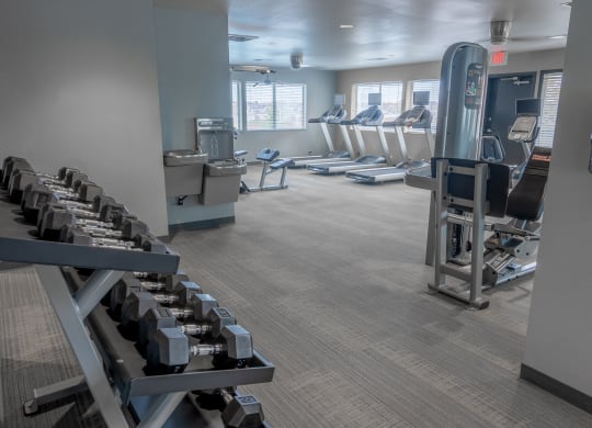 a gym with cardio equipment and chairs in it