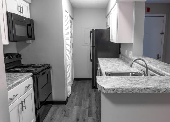 an empty kitchen with granite counter tops and stainless steel appliances