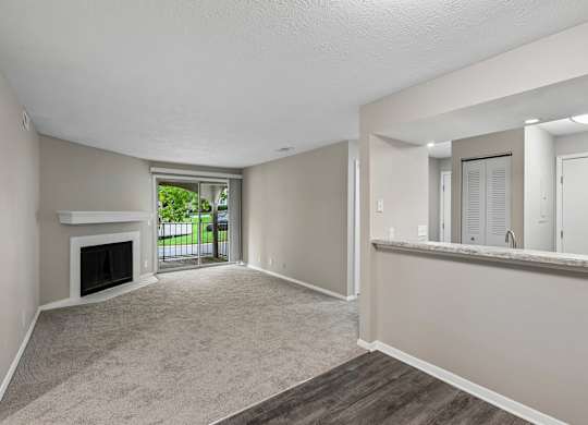 A spacious living room with a fireplace and a view of the backyard.