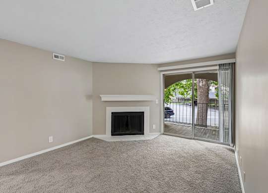 A living room with a fireplace and sliding glass doors.
