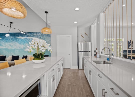 a white kitchen with white cabinets and a blue wall