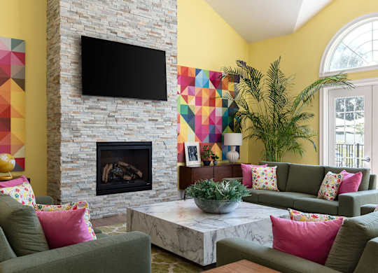 A living room with a fireplace and a flat screen TV mounted above it.