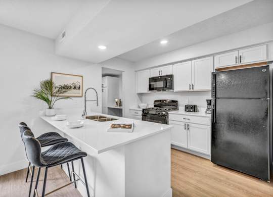 A kitchen with a white countertop and black appliances.
