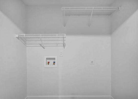 A white room with a shelf and a picture on the wall.