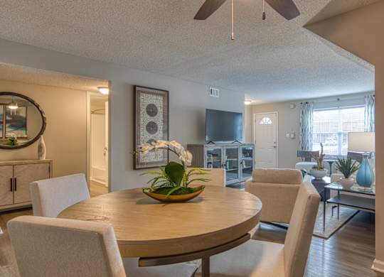 A dining room with a round table and chairs.