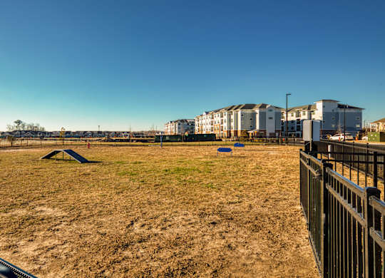 A playground with a swing set and a fence in the foreground.