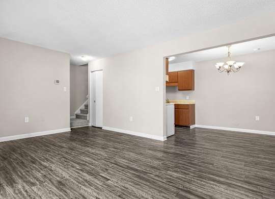 A room with wood flooring and a chandelier.