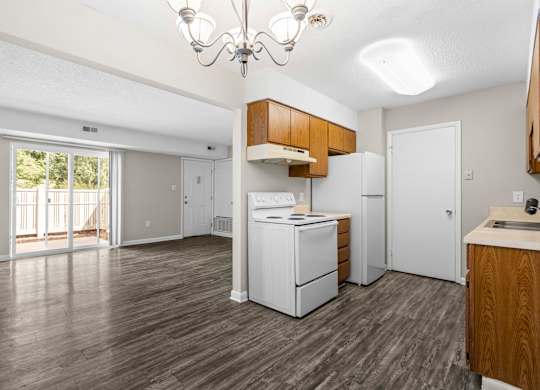 A kitchen with white appliances and wooden cabinets.