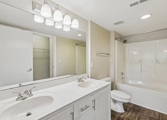 A white bathroom with a sink, toilet, and bathtub.