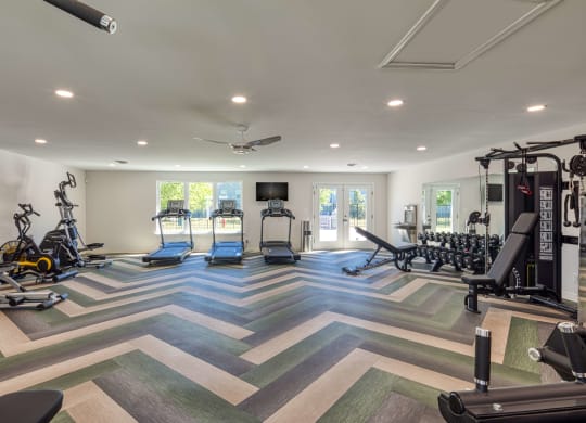a spacious fitness room with treadmills and other exercise equipment