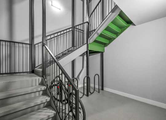 A staircase with a metal railing and a green staircase.