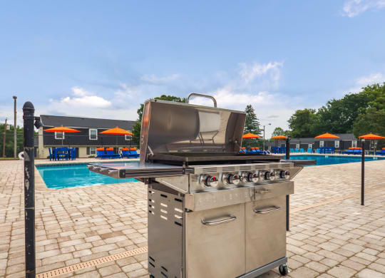 a stainless steel grill next to a swimming pool