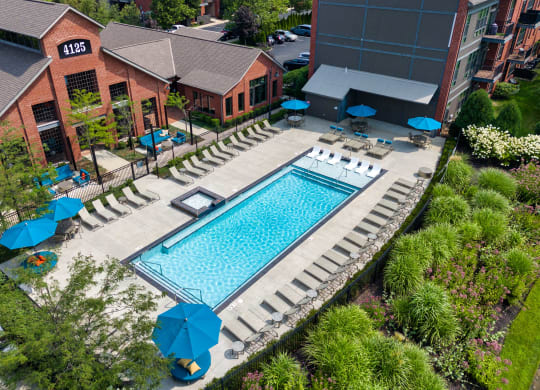 a resort style swimming pool in front of a hotel with umbrellas at Hayden Lofts, Dublin