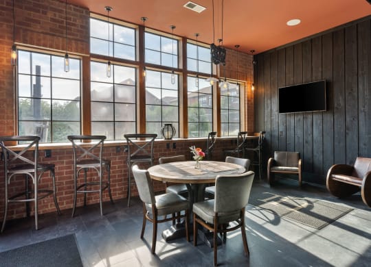 a dining area with a table and chairs and a wall of windows at Hayden Lofts, Ohio