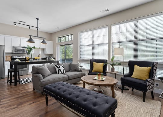 an open living room and kitchen with a couch and chairs at Hayden Lofts, Dublin, OH, 43016