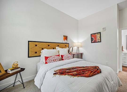 A bedroom with a large bed and a wooden headboard.