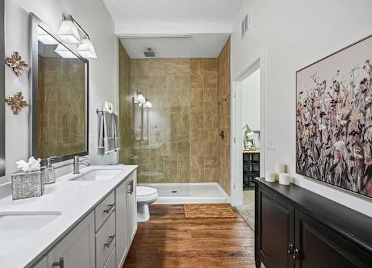 A bathroom with a brown floor and a brown shower.