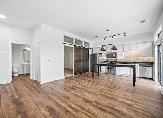 A kitchen with a wooden floor and white walls.