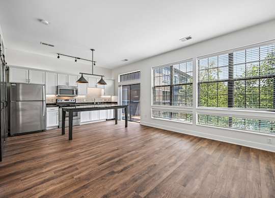 A kitchen with a wooden floor and a table with chairs.