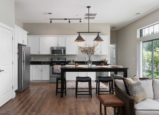 a kitchen and living room with a table and chairs and a refrigerator at Hayden Lofts, Dublin, OH, 43016