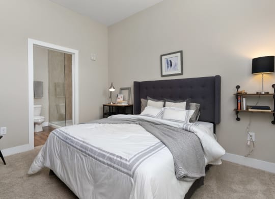a bedroom with a large bed and a bathroom with a shower at Hayden Lofts, Ohio