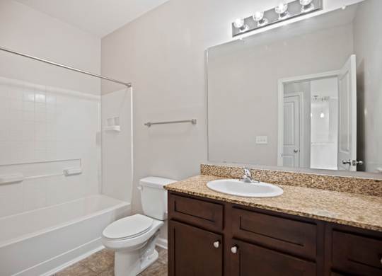 A white toilet sits next to a sink in a bathroom.