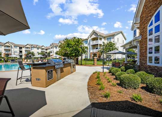 A sunny day at a poolside bar area with a view of apartment buildings in the background.