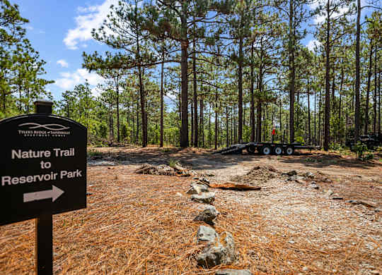 A signpost for the Nature Trail to Reservoir Park stands in a wooded area.