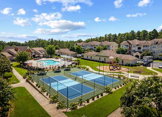 A tennis court surrounded by houses and trees.