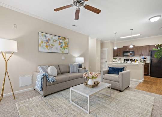 A living room with a grey couch, a coffee table, and a ceiling fan.