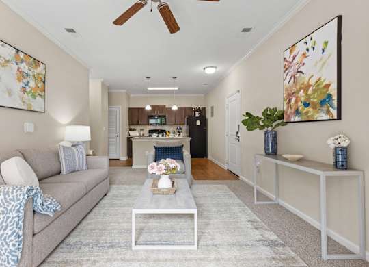 A living room with a grey couch and a glass coffee table.