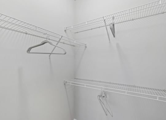 A white wire shelf with a hanger on it.