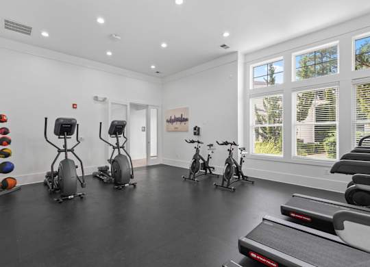 A room with exercise equipment and windows.