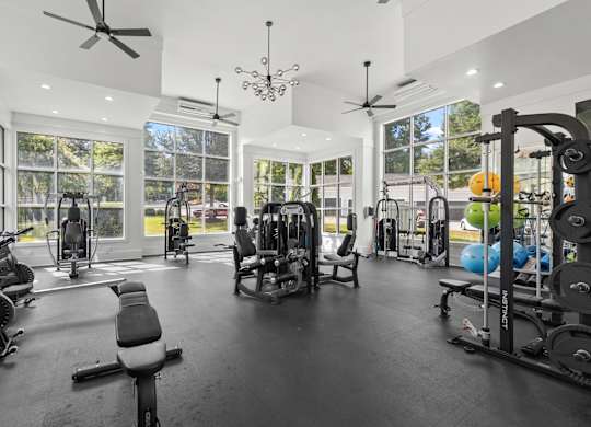 A spacious gym with a variety of equipment and a person working out.