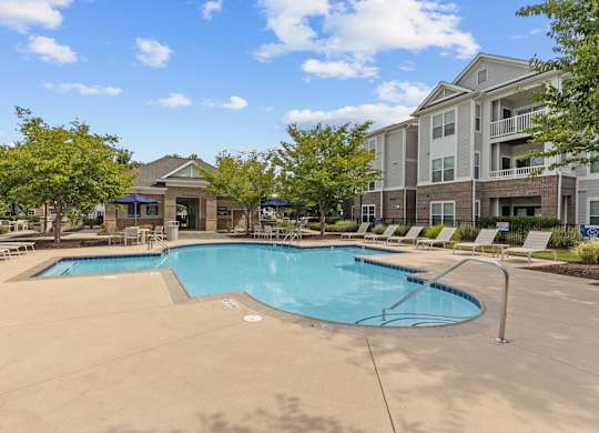 A large swimming pool in front of apartment buildings.