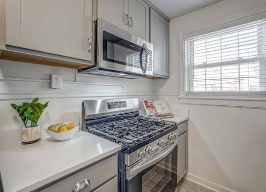 A kitchen with a stove top oven and a microwave above it.