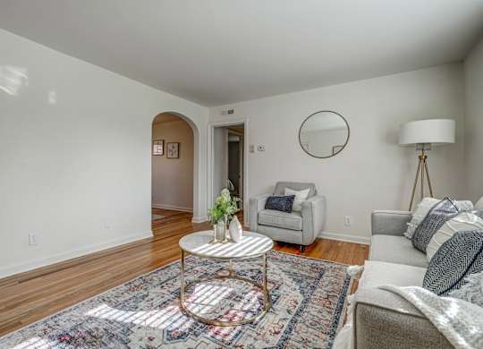 A living room with a round table and a grey couch.