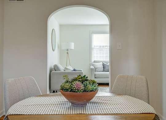 A dining room with a round table and chairs.