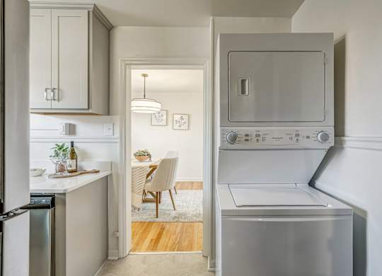 A modern kitchen with a dining area in the background.