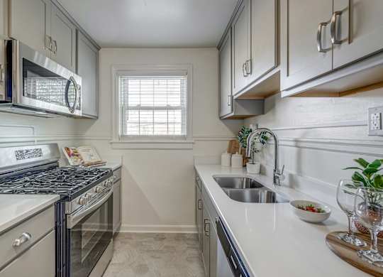 A kitchen with a stove, microwave, and sink.