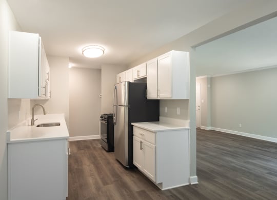 a kitchen with white cabinetry and a black refrigerator