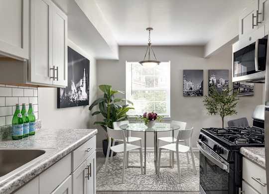 A modern kitchen with a dining table and chairs.