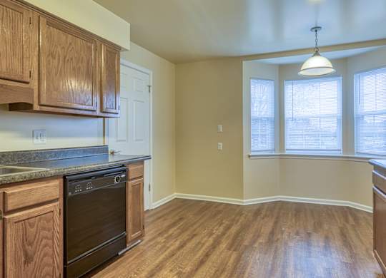 A kitchen with wooden cabinets and a black oven.