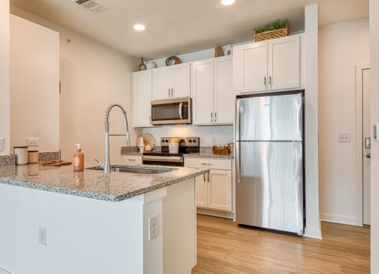 a kitchen with a granite counter top and a stainless steel refrigerator at Allure at Edinburgh, Virginia, 23322